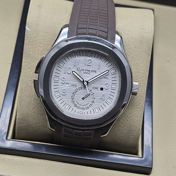 Réplica AAA de reloj Patek Philippe Aquanaut Advanced Research Travel Time en caja de acero, esfera blanca cuadriculada y correa de caucho marrón.