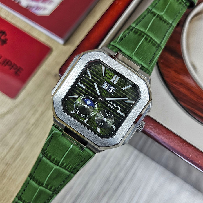 Réplica AAA de reloj Patek Philippe Cubitus en caja de acero con esfera verde oliva acanalada, gran fechador, fase lunar y correa de cuero verde.