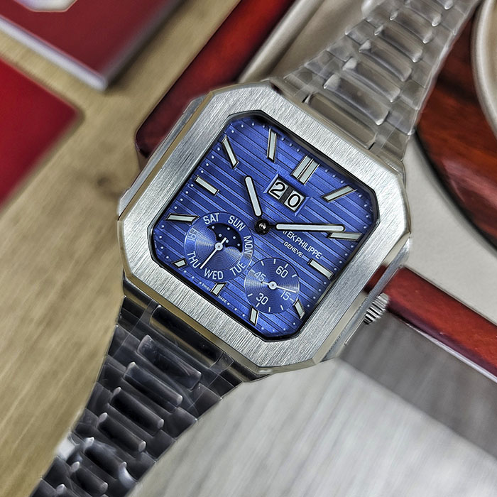 Réplica AAA Patek Philippe Cubitus en caja y brazalete de acero con rica esfera azul acanalada, gran fechador y fase lunar.