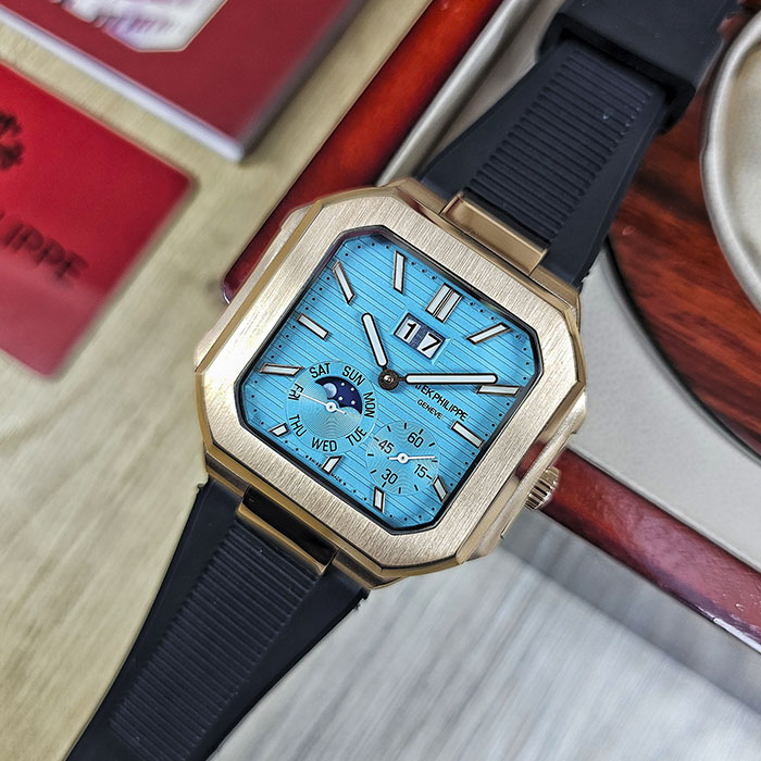 Réplica AAA Patek Philippe Cubitus en caja de oro rosa con brillante esfera azul turquesa, gran fechador panorámico y correa de caucho negra.
